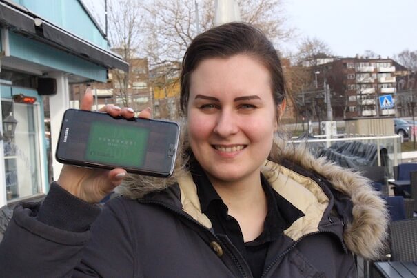Bilde av Christina som viser frem telefonen med Donorkort™