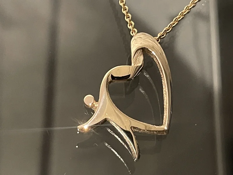 Stiftelsen Organdonasjon sin logo, hjertemannen, utført som gullsmykke i kjede