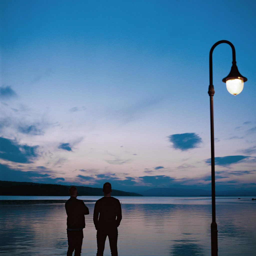 Bilde av Lars Marius og Anders som står og skuer utover sjøen i skumringen.